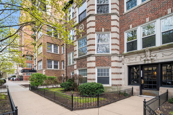 Front view of a multi-story brick building with ornate entrance.