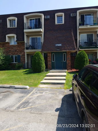 Front view of a three-story apartment building with balconies.