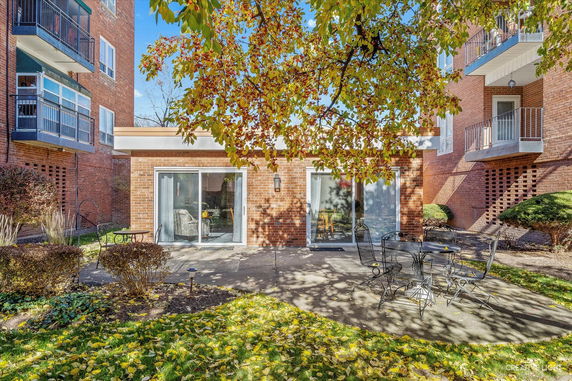Front view of a brick building with multiple stories and sliding glass doors on the ground floor.