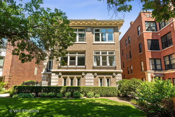 Front view of a multi-story brick building with large windows.