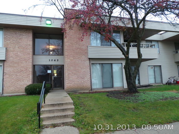 Front view of a brick building with large windows and a walkway.