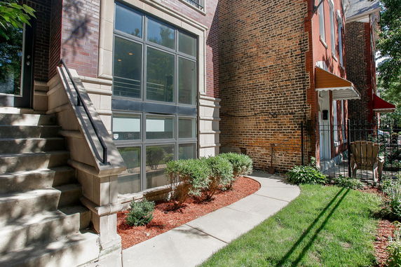 Front view of a building with large windows and a staircase leading to the entrance