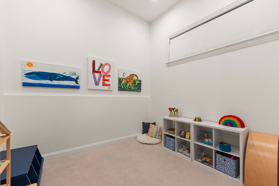 Small indoor children's playroom with wall art and toy storage.