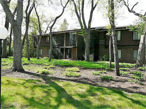Front view of a two-story building surrounded by trees.
