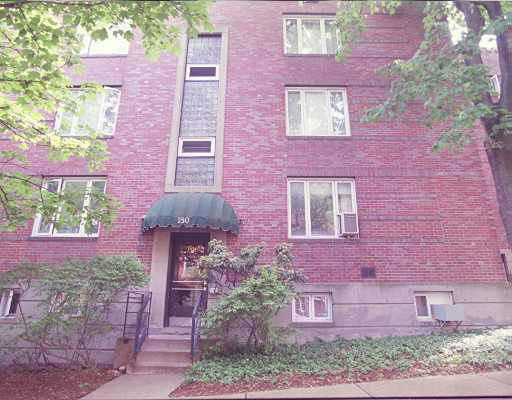 Front view of a multi-story brick building with multiple windows.