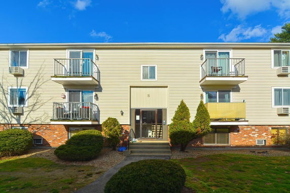 Front view of a multi-story apartment building with balconies.