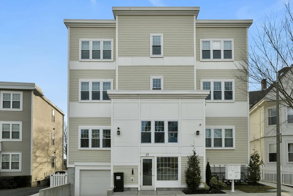 Front view of a multi-story residential building with multiple windows.