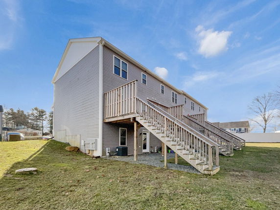 Side view of a multi-story building with external staircases leading to upper levels.