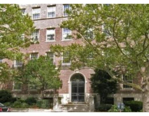 Front view of a multi-story brick building with arched entrance.