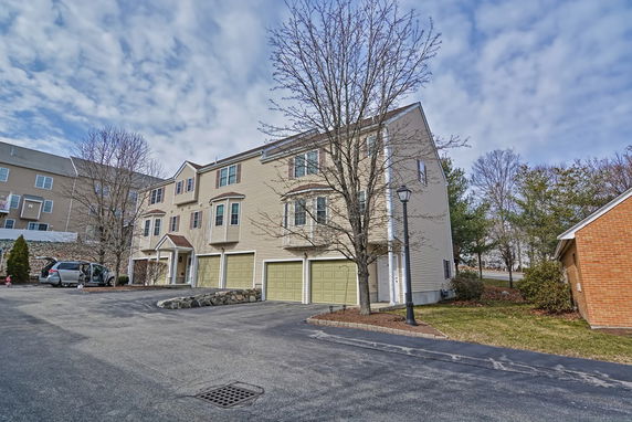 Front view of a multi-story residential building with garages.