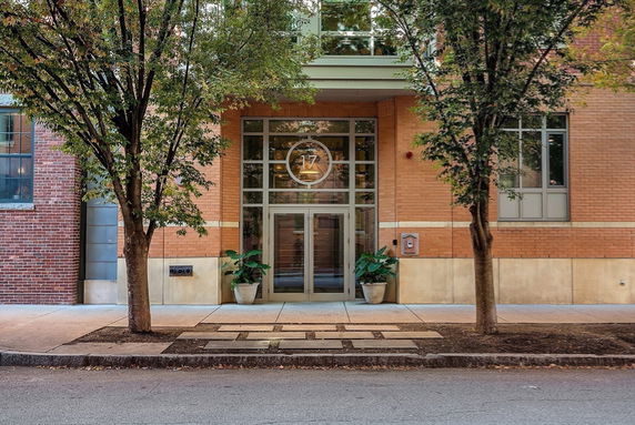 Front view of a building entrance with glass doors and brick exterior.