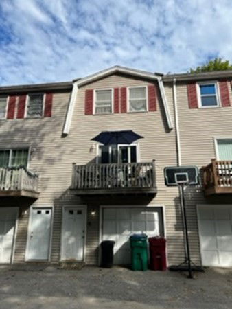 Front view of a two-story townhouse with a garage and balcony.