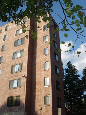 Corner view of a multi-story brick apartment building.
