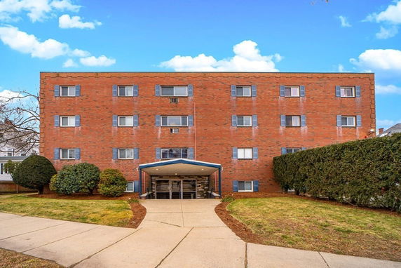 Front view of a multi-story brick building with multiple windows.