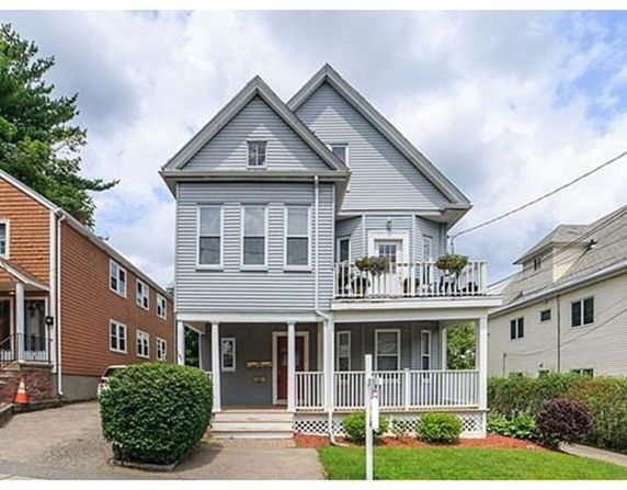 Front view of a two-story house with a covered porch and balcony.