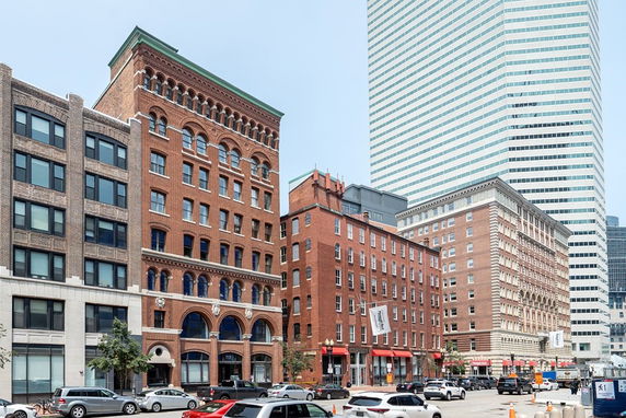 Front view of multiple multi-story brick buildings in an urban setting.