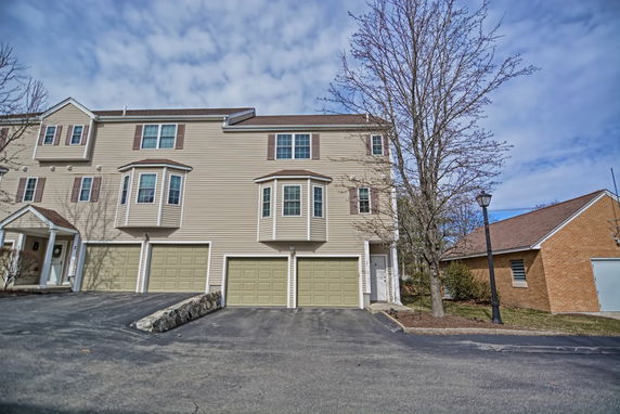 Front view of a multi-story residential building with garages.
