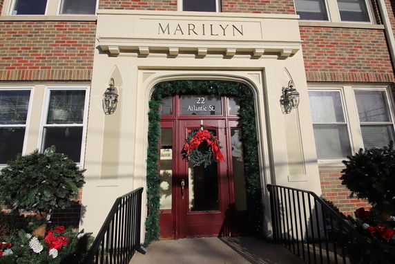Front view of a brick building entrance with festive decorations.