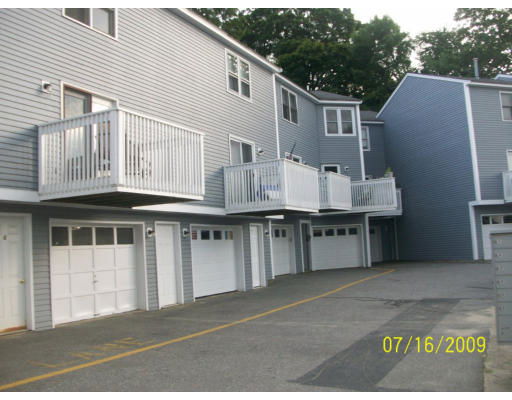Front view of a multi-story residential building with balconies and garages.
