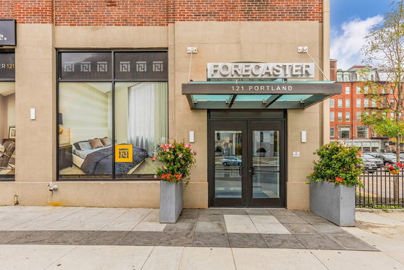 Front view of a building entrance with signage and large windows.