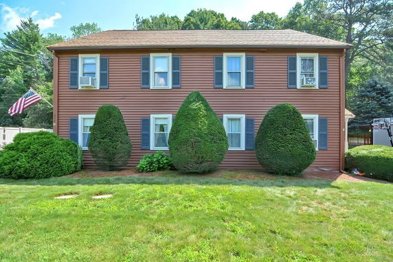 Front view of a two-story house with brown siding and blue shutters.