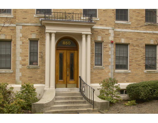Front view of a building entrance with brick facade and columns.
