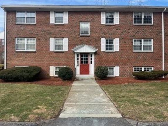 Front view of a two-story brick apartment building with a central entrance.