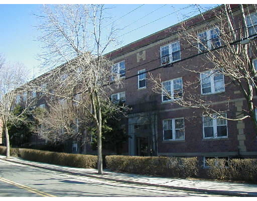 Front view of a multi-story brick building with multiple windows.