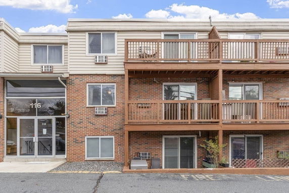 Front view of a multi-story building with brick facade and multiple balconies.