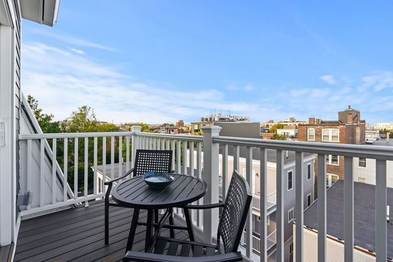 View from a balcony overlooking urban rooftops and buildings.