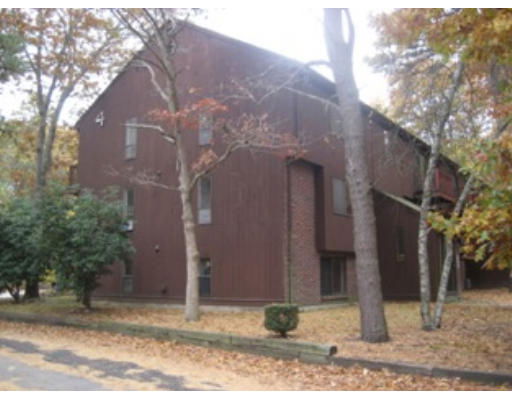 Front view of a multi-story apartment building with wooden exterior.