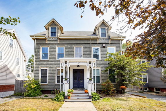 Front view of a two-story house with a gabled roof and a covered porch.