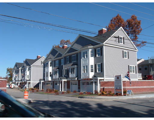 Front view of multi-story residential buildings with gray siding and multiple garage doors.