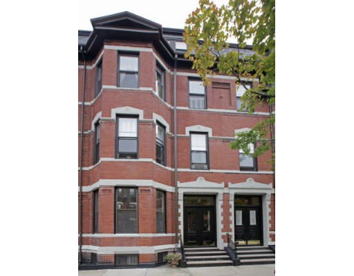 Front view of a multi-story brick building with multiple windows.
