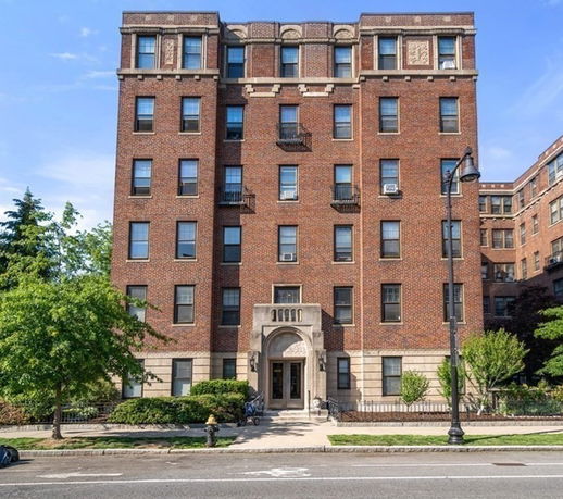 Front view of a multi-story brick building with a central entrance.