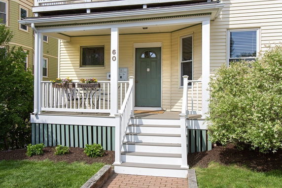 Front view of a house with a porch and steps leading to the entrance.