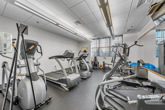 Indoor gym area with exercise equipment including treadmills and elliptical machines.