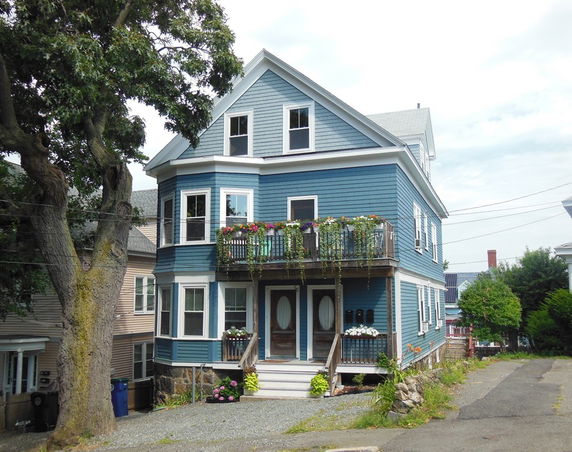 Front view of a multi-story house with blue exterior and a small balcony.
