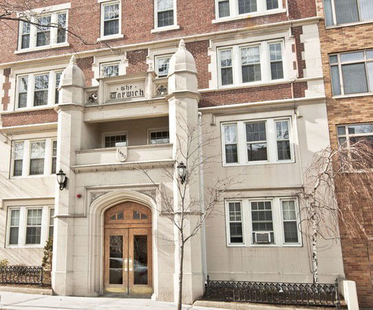 Front view of a multi-story residential building with a decorative entrance.
