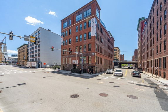Front view of a multi-story brick building at a street intersection.