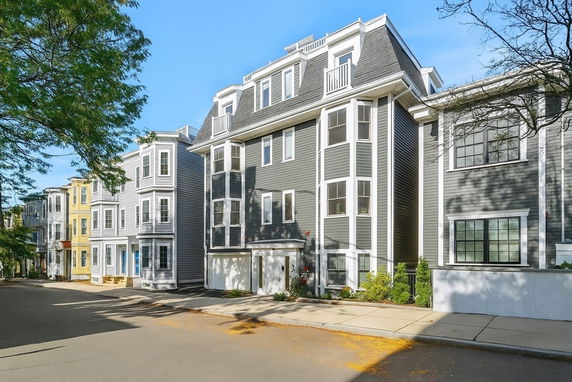 Front view of a multi-story residential building with a gray facade.