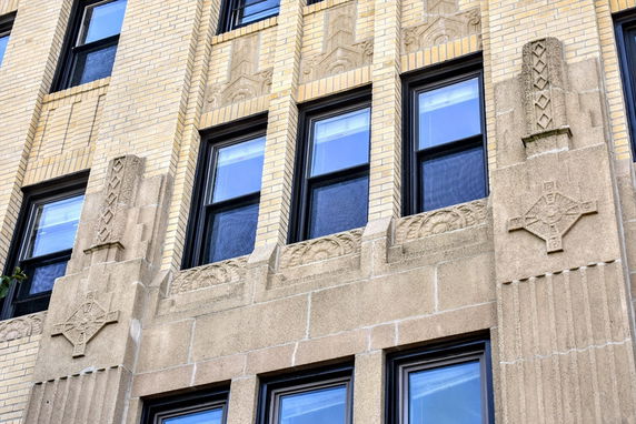 View of a building facade with decorative stonework and multiple windows.