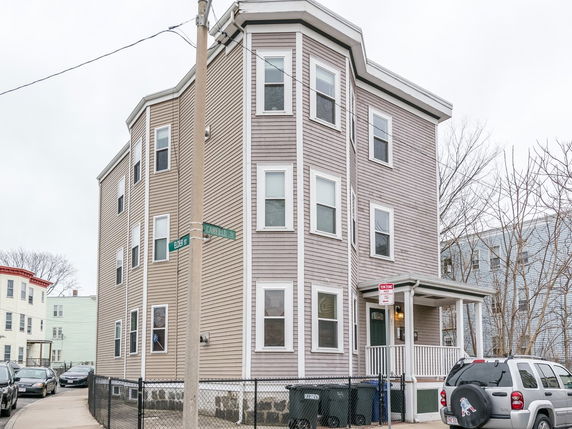 Front view of a multi-story house with siding exterior and multiple windows.