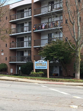 Front view of a multi-story condominium building with balconies.