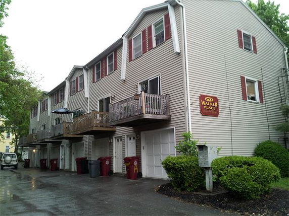 Front view of a multi-story townhouse complex with small balconies.