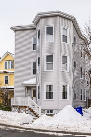 Front view of a multi-story house with a bay window design.