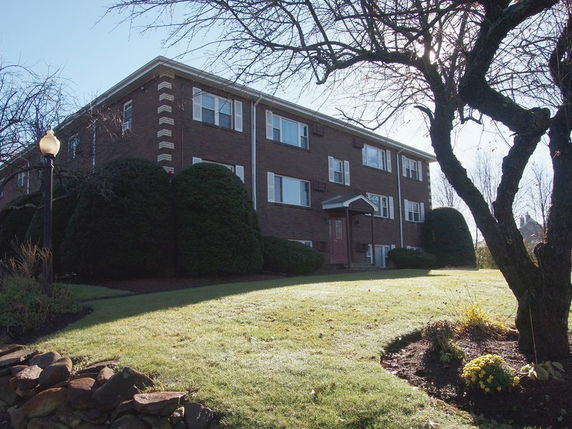 Front view of a two-story brick building with multiple windows and a central entrance.