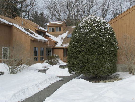 Front view of a multi-story house with wooden exterior and snow-covered surroundings.