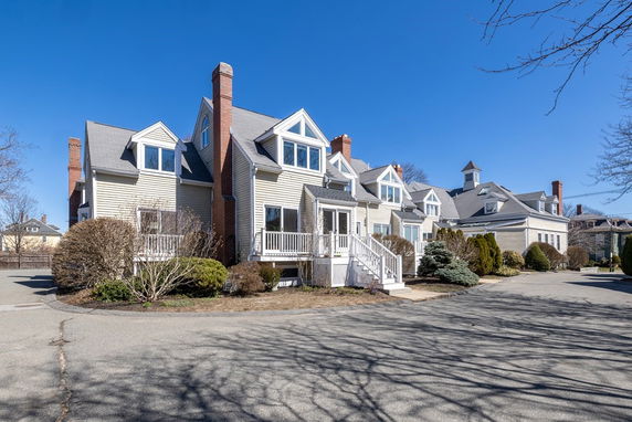 Front view of a multi-story house with dormer windows and chimneys.