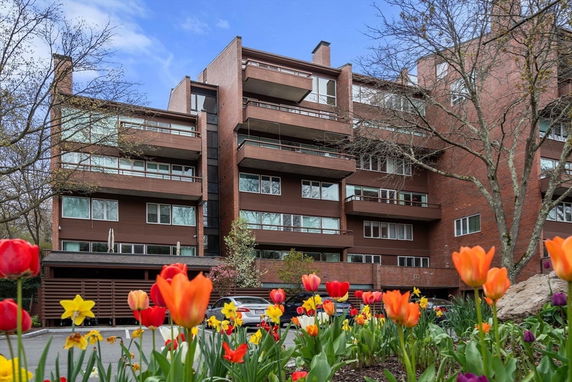 Front view of a multi-story brick apartment building with balconies.